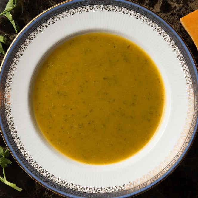 Butternut squash and lemongrass soup in a bowl, garnished with coriander.
