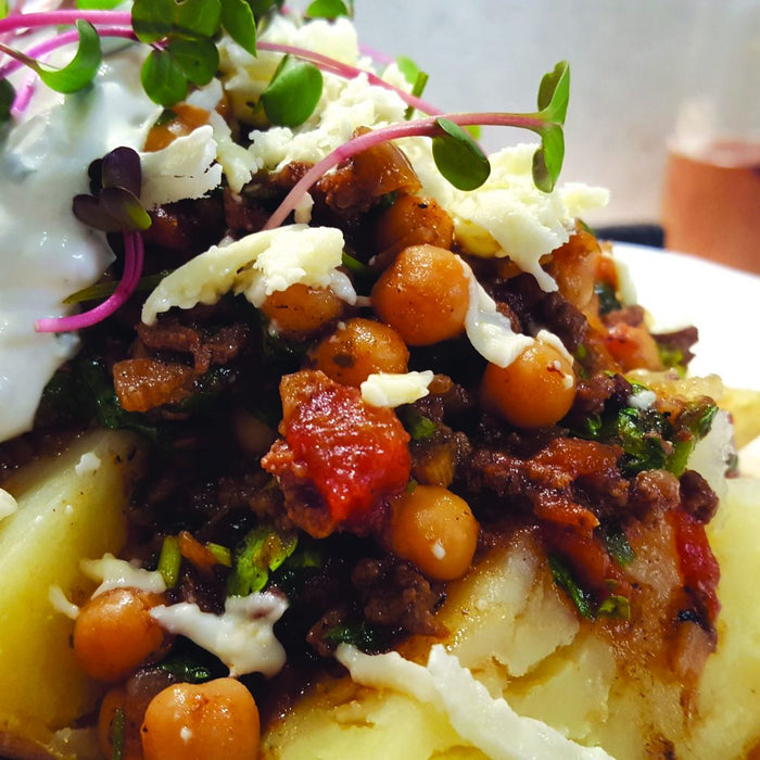 Chilli con carne with chickpeas, served over jacket potato with soured cream and coriander.