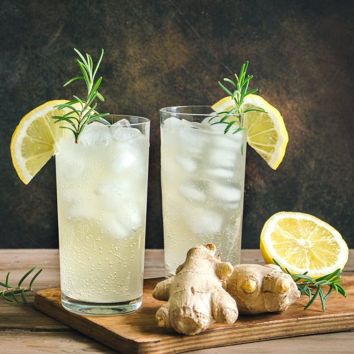 Ginger sour fizz cocktail made with Ginger Spice Drops, garnished with lemon and rosemary.