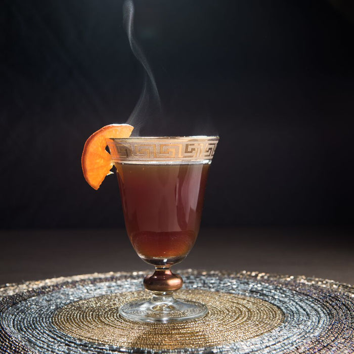 Mulled wine with whiskey, garnished with a clementine slice.
