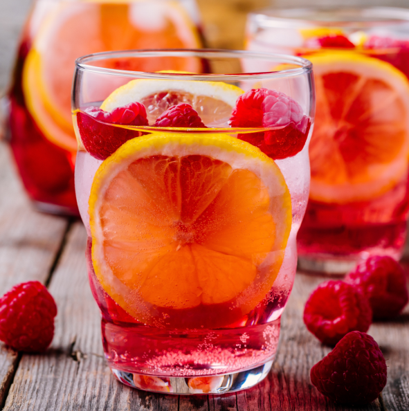 Rose and raspberry refresher made with Rose Spice Drops, garnished with raspberries and lemon.