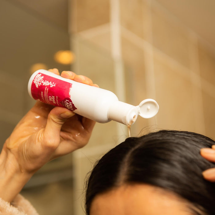 Bottle of Holy Lama Naturals Ayurvedic herbal hair oil with coconut oil.