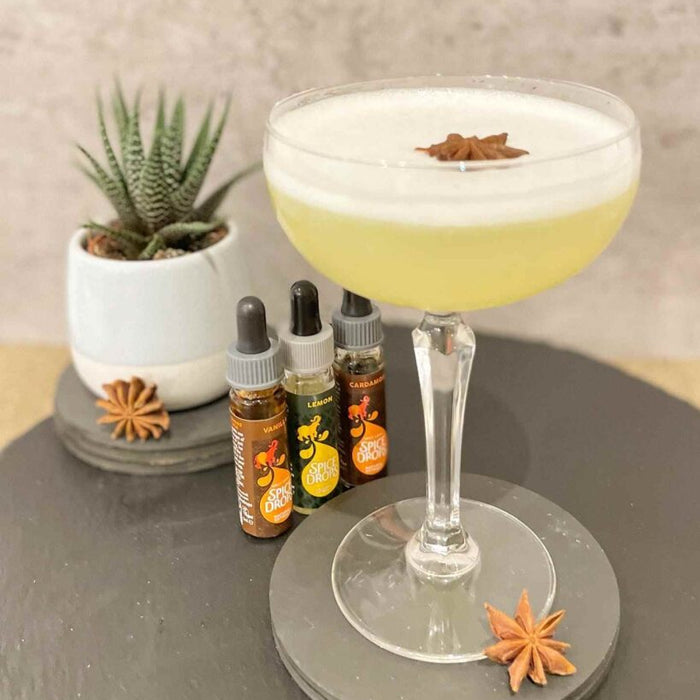 The Vanilla Grove Sour cocktail in a coupe glass, made with Vanilla and Cardamom Spice Drops.