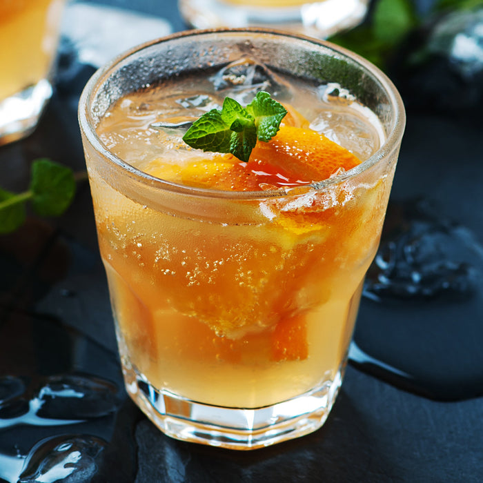 Citrus spritz cocktail made with Lime Zest and Orange Zest Spice Drops, garnished with orange.