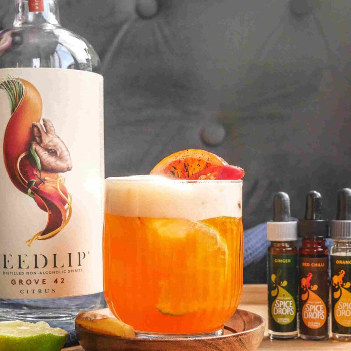 Sugar and Spice mocktail garnished with red chilli and ginger, made with Holy Lama Spice Drops.