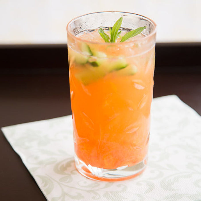 Tropical cooler made with Spice Drops, a zesty fruit juice drink garnished with mint.